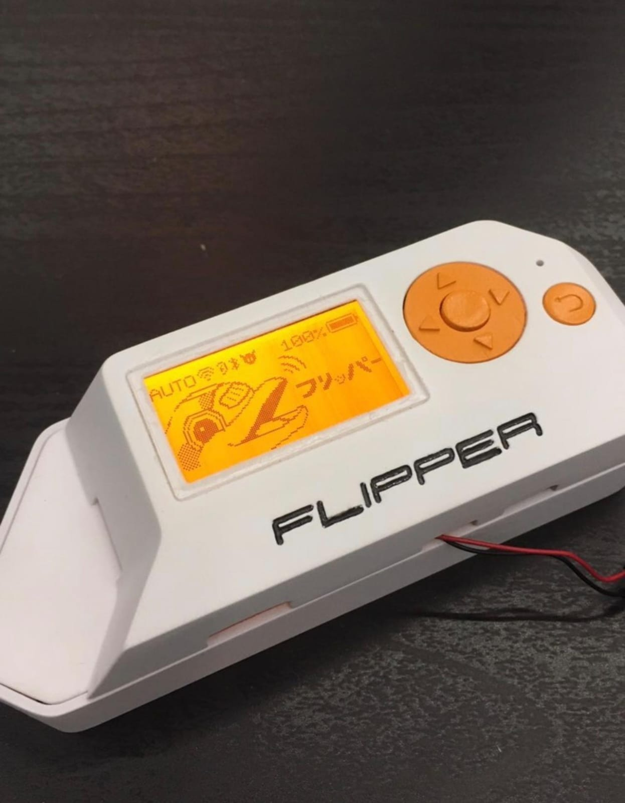 Prototipo funcional temprano de Flipper con pantalla naranja, cruceta y cables visibles